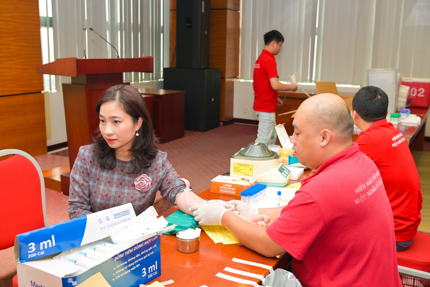 Người tham gia hiến máu được hỗ trợ lấy mẫu và xét nghiệm máu.