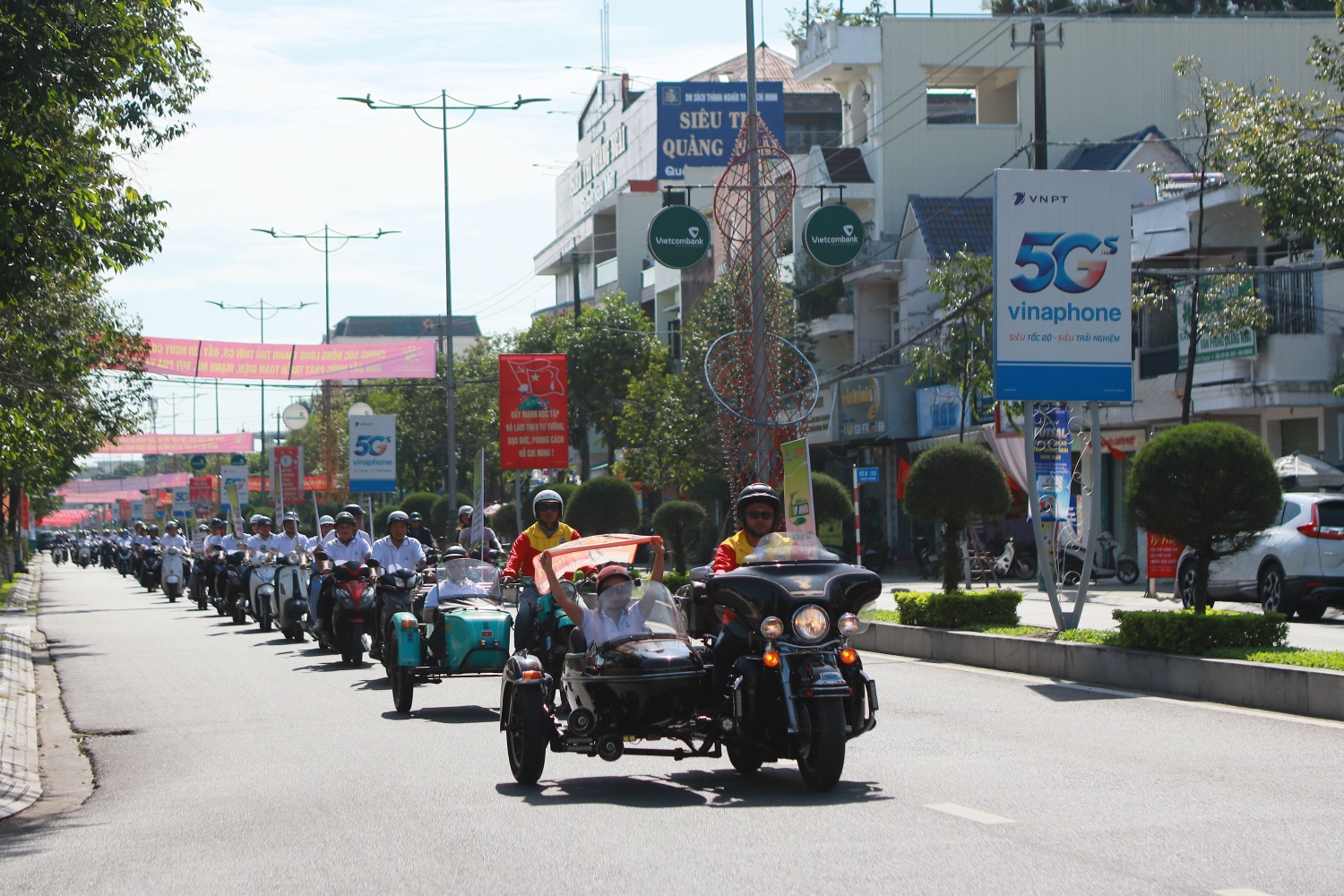 Dọc theo tuyến đường Hùng Vương, đông đảo người dân đã bị thu hút bởi hàng dài xe gắn băng rôn tuyên truyền về việc sử dụng xăng sinh học E10 RON 95.