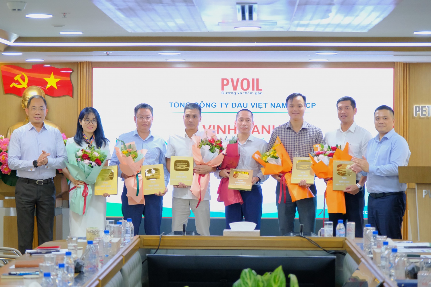 Đ/c Cao Hoài Dương – Bí thư Đảng ủy, Chủ tịch HĐQT Tổng công ty (bên trái) và đ/c Nguyễn Đăng Trình – Phó Bí thư Đảng ủy, Tổng Giám đốc Tổng công ty (bên phải) trao biểu trưng vinh danh cho đại diện các đơn vị có CHXD tiêu biểu