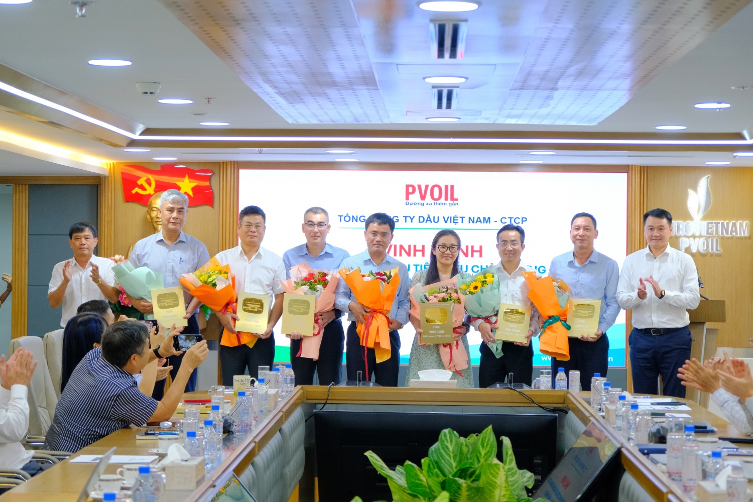 Đ/c Nguyễn Mậu Dũng – Thành viên HĐQT Tổng công ty (bên trái) và đ/c Lê Trung Hưng – UVBTV Đảng ủy, Phó Tổng Giám đốc Tổng công ty (bên phải) trao biểu trưng vinh danh cho đại diện các đơn vị có CHXD tiêu biểu