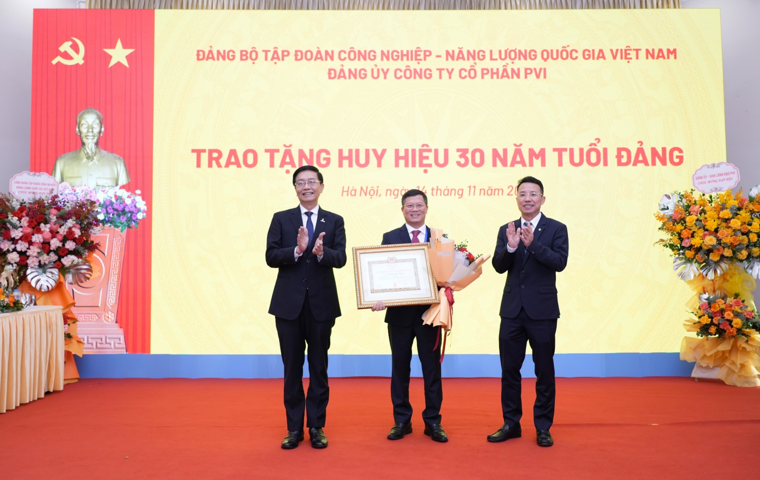 Đồng chí Trần Quang Dũng, Phó Bí thư Thường trực Đảng ủy Petrovietnam và đồng chí Nguyễn Tuấn Tú, Bí thư Đảng uỷ, Phó Chủ tịch HĐQT, Tổng Giám đốc PVI trao tặng huy hiệu 30 năm tuổi đảng cho đoàn viên Nguyễn Văn Chỉnh.