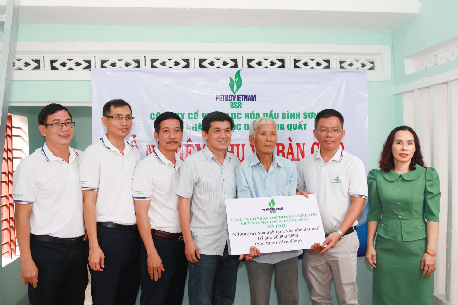 Đại diện Khối Nhà máy lọc hoá dầu Dung Quất trao biển tượng trưng căn nhà mới cho ông Huỳnh Kiễn.