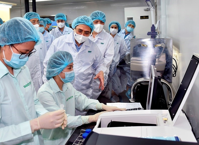 Thủ tướng Phạm Minh Chính thăm hỏi, động viên các các bộ đang làm việc tại Viện Vệ sinh dịch tễ Trung ương và Công ty VABIOTECH. Ảnh: VGP